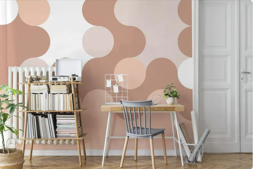 Stylish workspace with wooden desk, gray chair, and pastel circle wallpaper striping, shelves with books and decor.