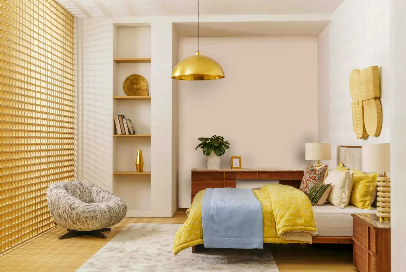 Stylish bedroom with gold pendant light, yellow-blue bedding, wooden side table, and armchair, ideal for bedroom and guest room suits.