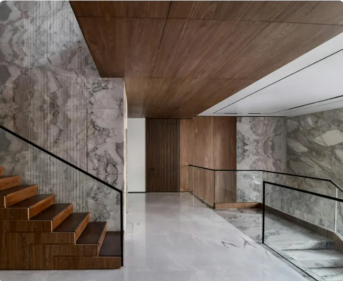 Modern staircase with marble walls and rich wood paneling, blending luxury and style for marble wall and wood faux finishes.