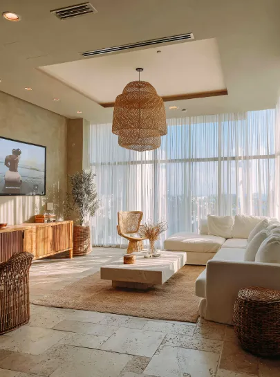 Bright airy living room with woven pendant light, white sofa, wooden furniture, and large windows for ceiling light removal ideas.