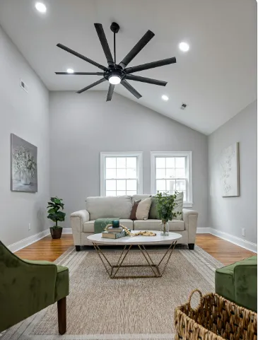 Modern gray living room with sofa, coffee table, and large ceiling fan, showcasing stylish ceiling fan light remodeling ideas.