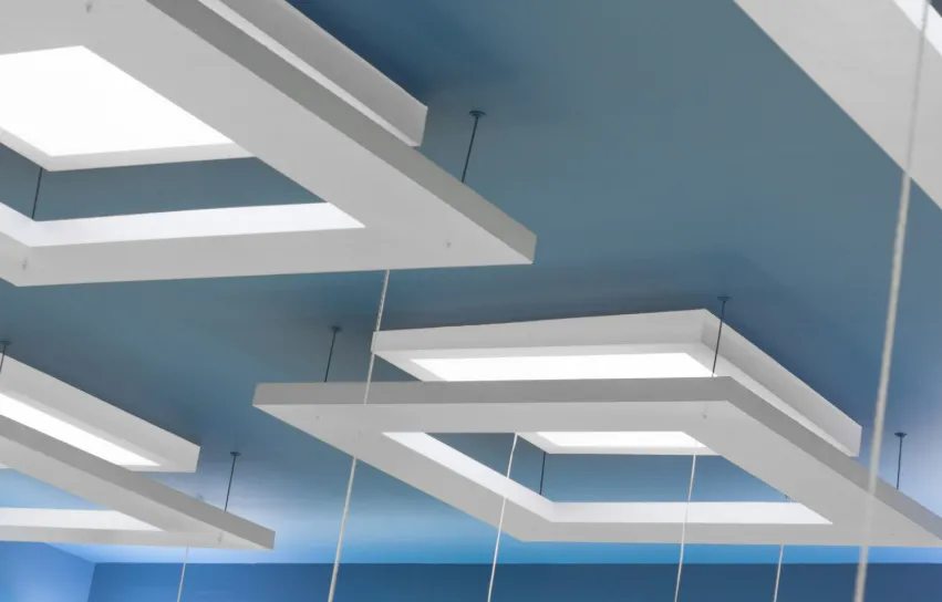 Modern ceiling with rectangular white light panels on a blue surface, creating a sleek look for popcorn texture removal ideas.