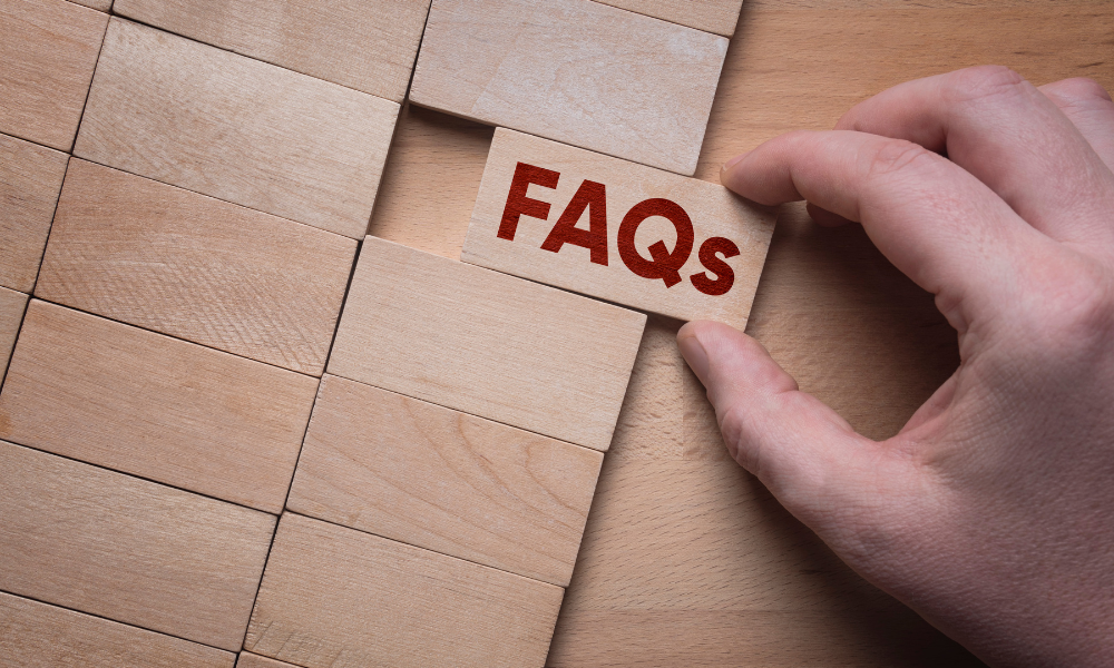 A hand pulls a wooden block labeled "FAQs" from a grid of plain blocks, symbolizing accessing information. The tone is informative and focused.