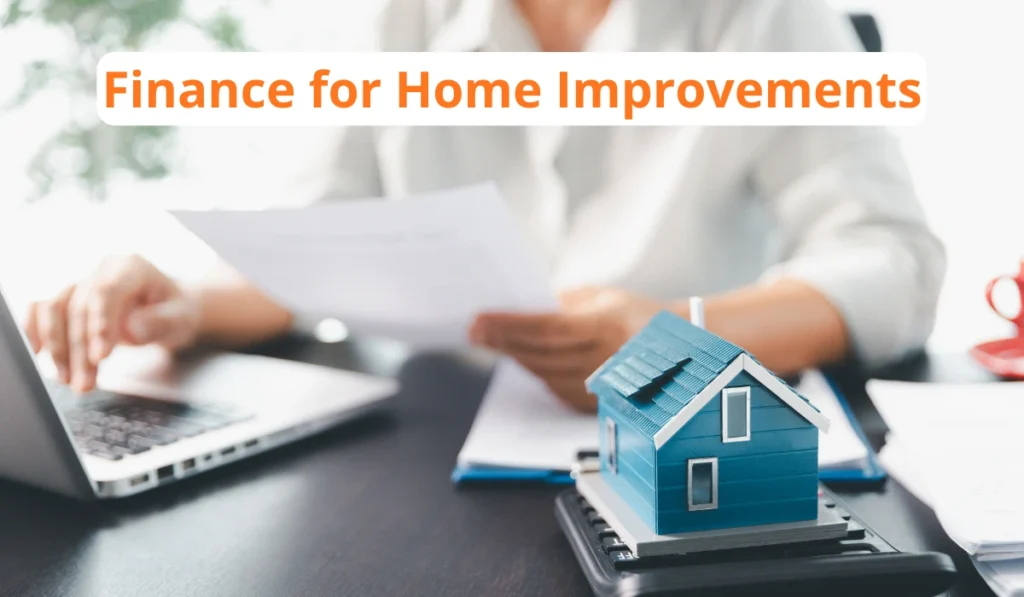 Home improvement financing concept with paperwork, laptop, and model house on a calculator.